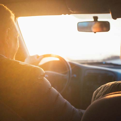Man driving car at sunset