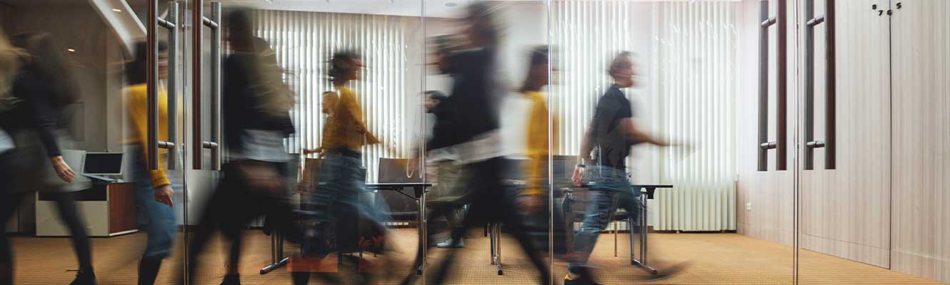 Businesspeople walking at modern office. Group of business employees at coworking center. Motion blur. Concept work process.